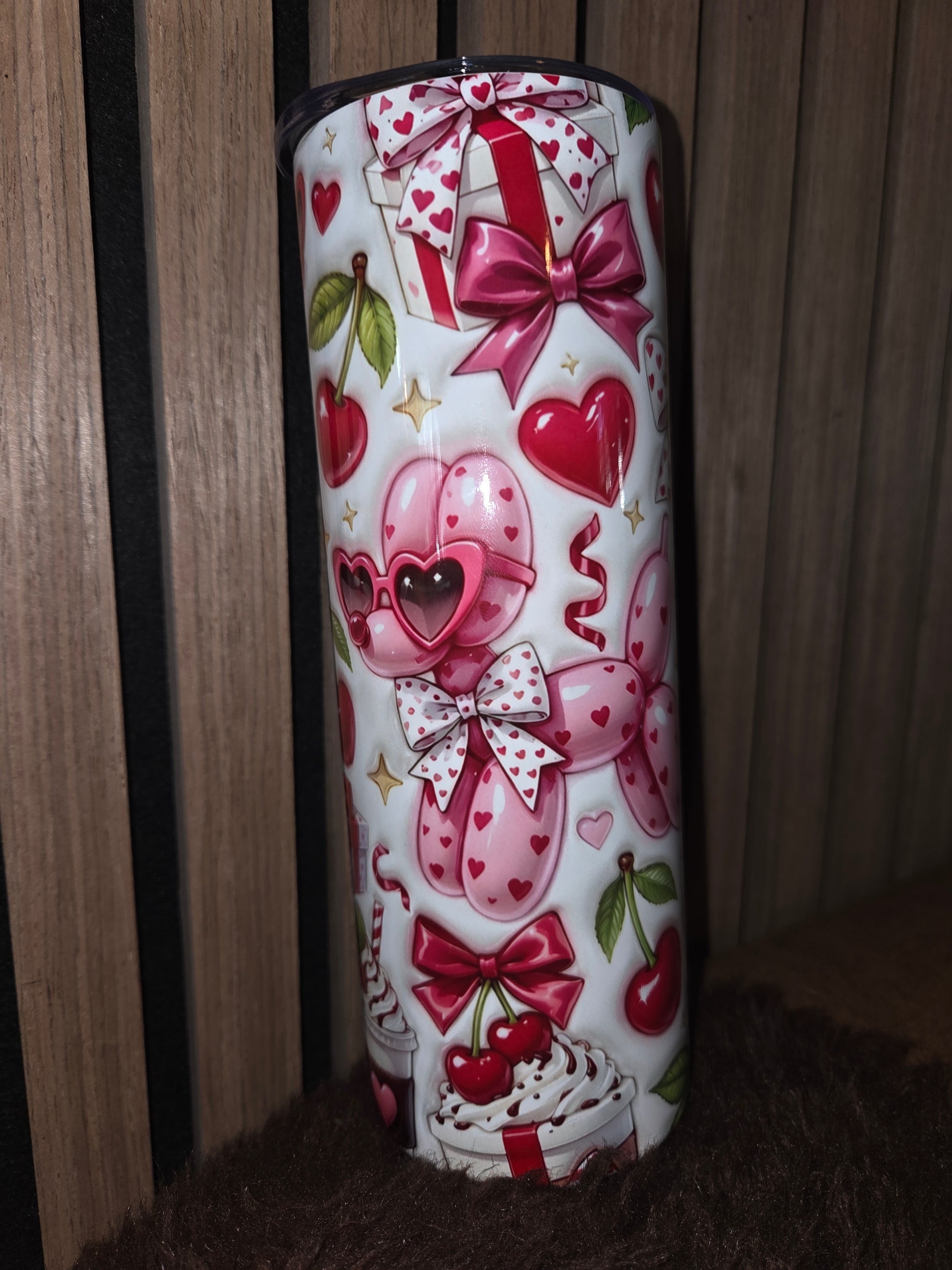 Tumbler met kersenprint en roze ballonnenhond op een lichte achtergrond